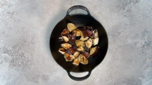 eggplant being roasted in a pot for vegan green curry