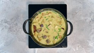 vegan green curry cooking in a pot