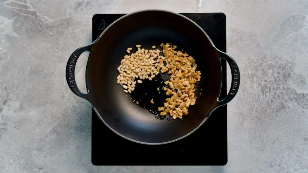 Walnuts and Pine nuts roasting in a pot