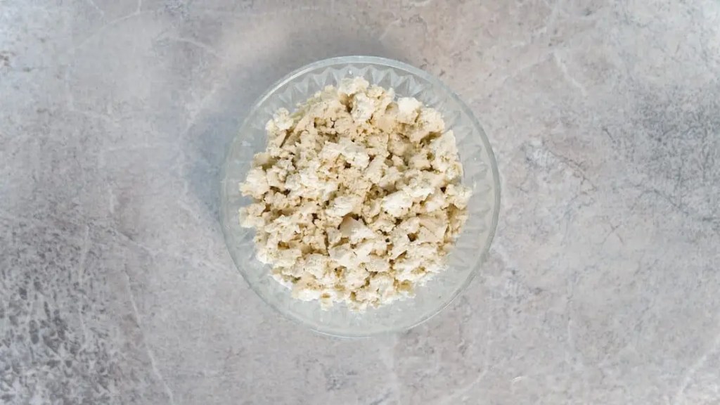 Broken down block of tofu in a bowl for vegan scrambled tofu