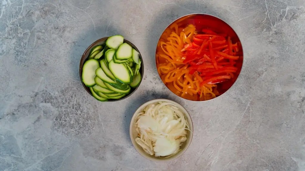Three bowls of chopped up vegetables